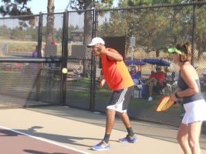 ENRIQUE RUIZ PREPARES TO SERVE AS GIGI LEMASTER LOOKS ON